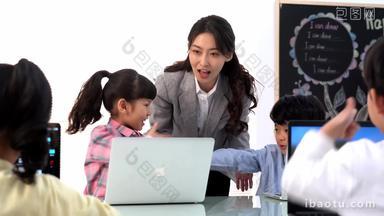 年轻老师辅导小朋友们使用电脑